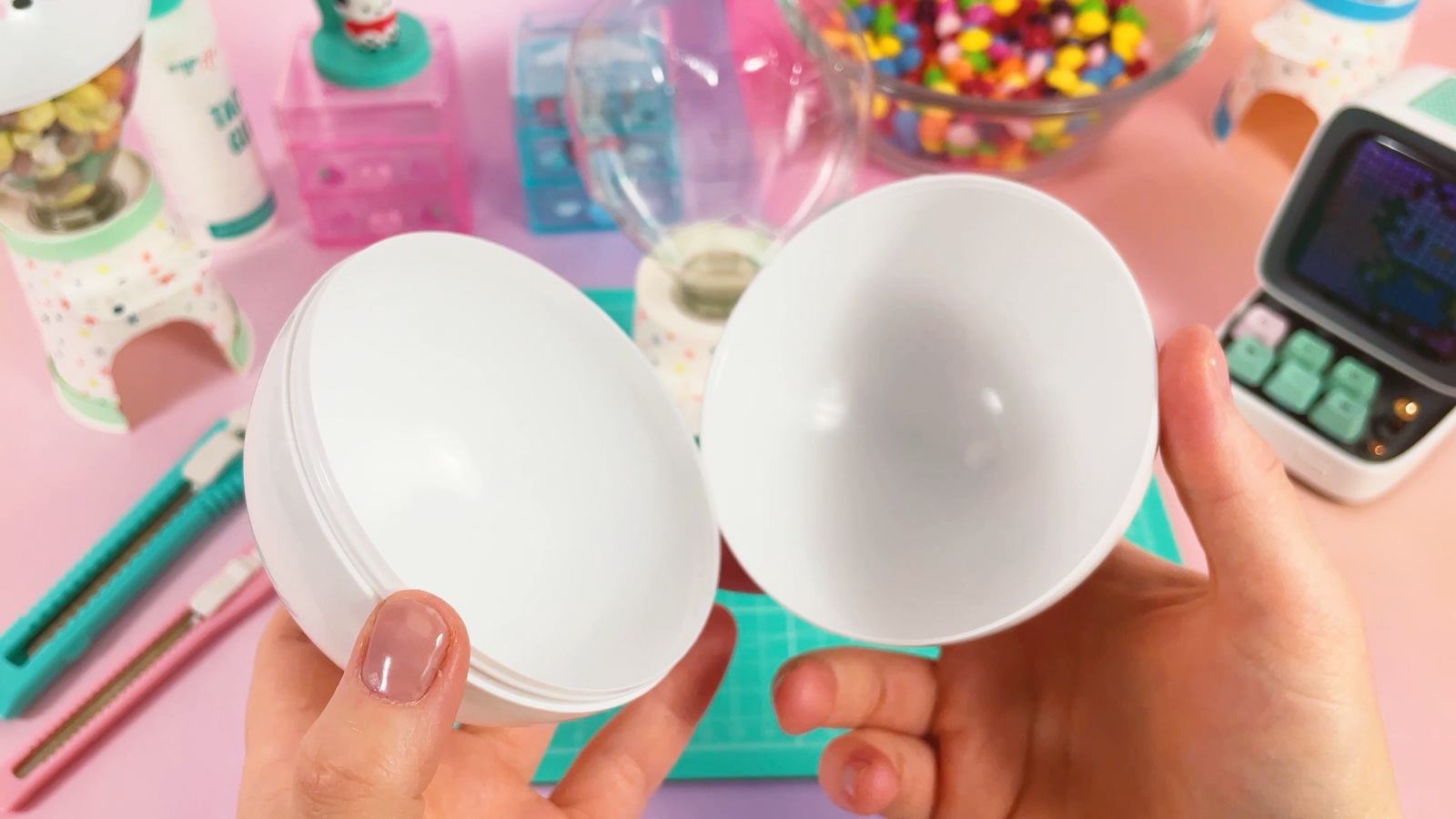 Les deux moitiés blanches d’une capsule en plastique ouverte, tenues dans les mains