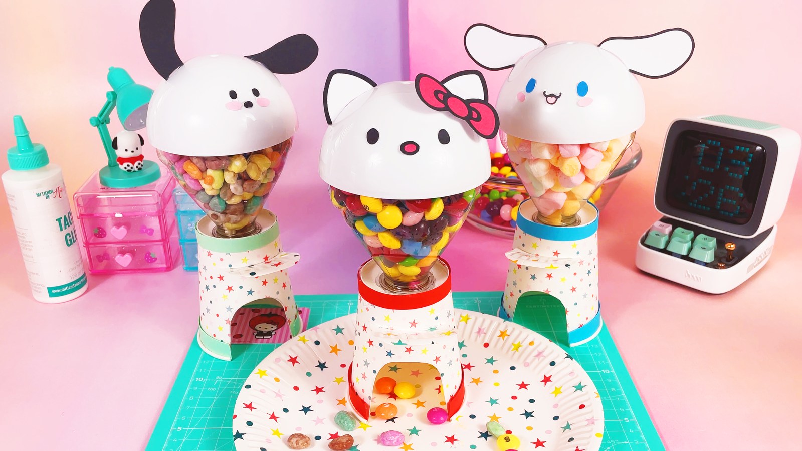 Three finished Sanrio candy machines with Pochacco, Hello Kitty and Cinnamoroll heads, full of sweets, on a mint cutting mat with a star plate
