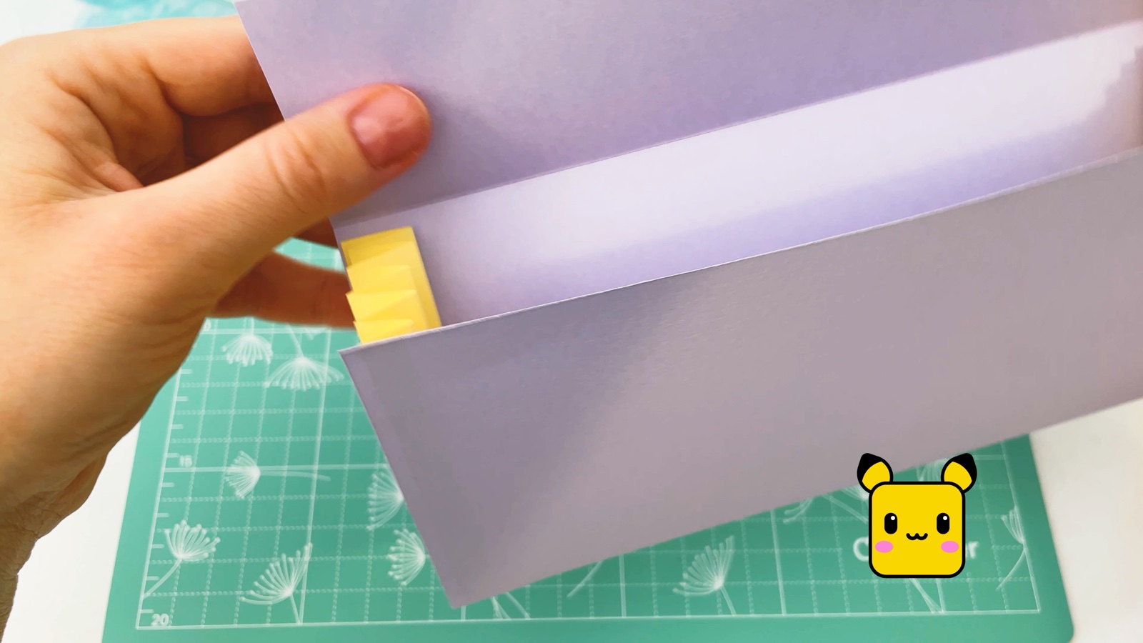 Se abre la billetera lila y el bolsillo amarillo en zigzag se estira por un lado