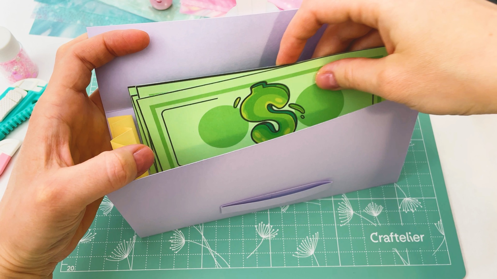 Se meten billetes de papel verdes en la billetera abierta, entre los bolsillos amarillos de los lados