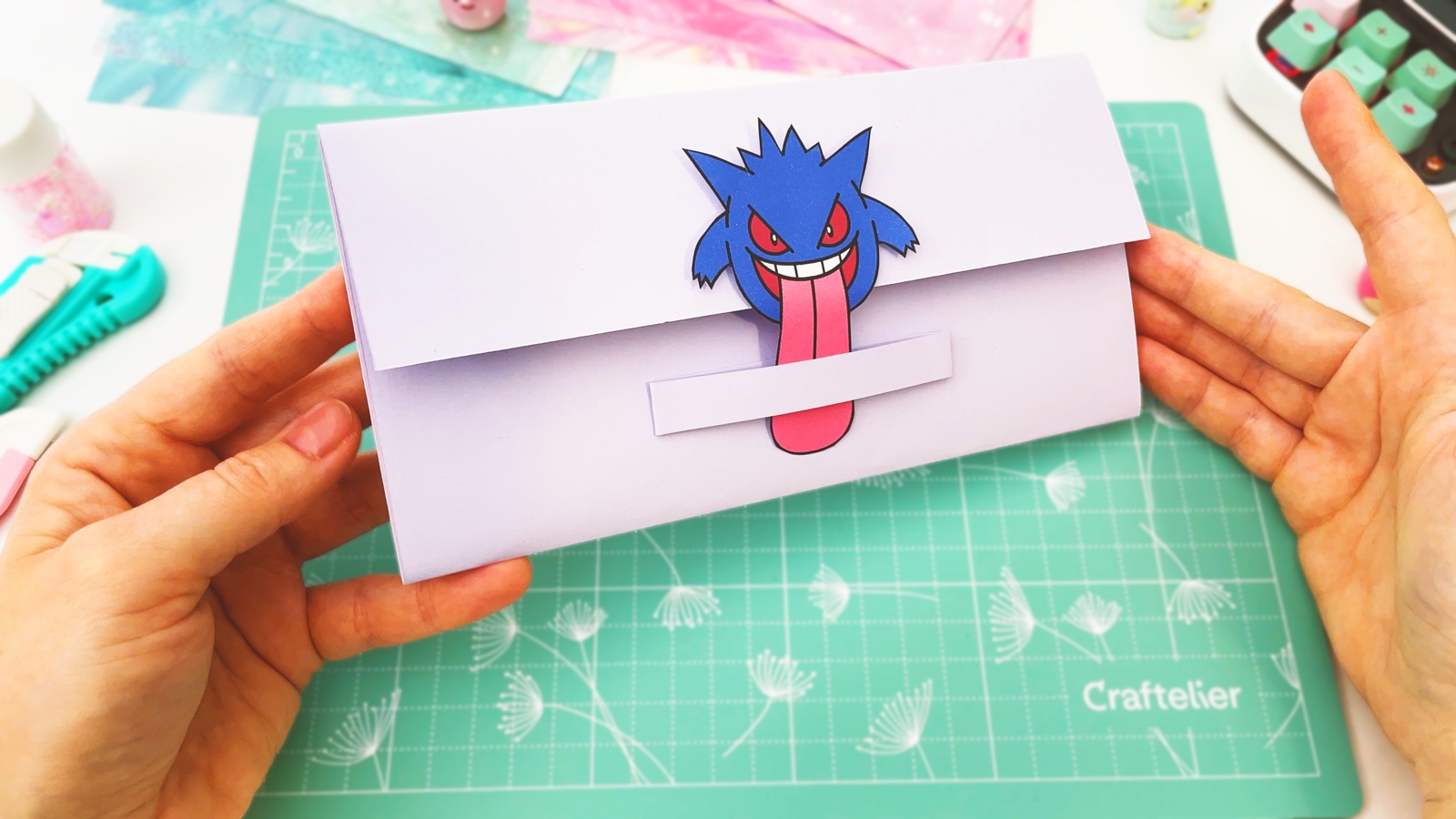 Finished light purple paper wallet seen from the side, Gengar on the flap and a yellow zigzag pocket at the edge