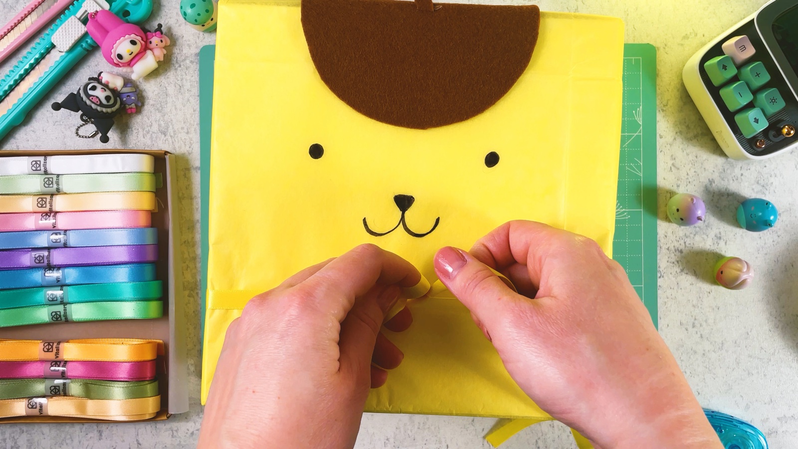 Se ata un listón de satín amarillo en un moño bajo la carita de Pompompurin