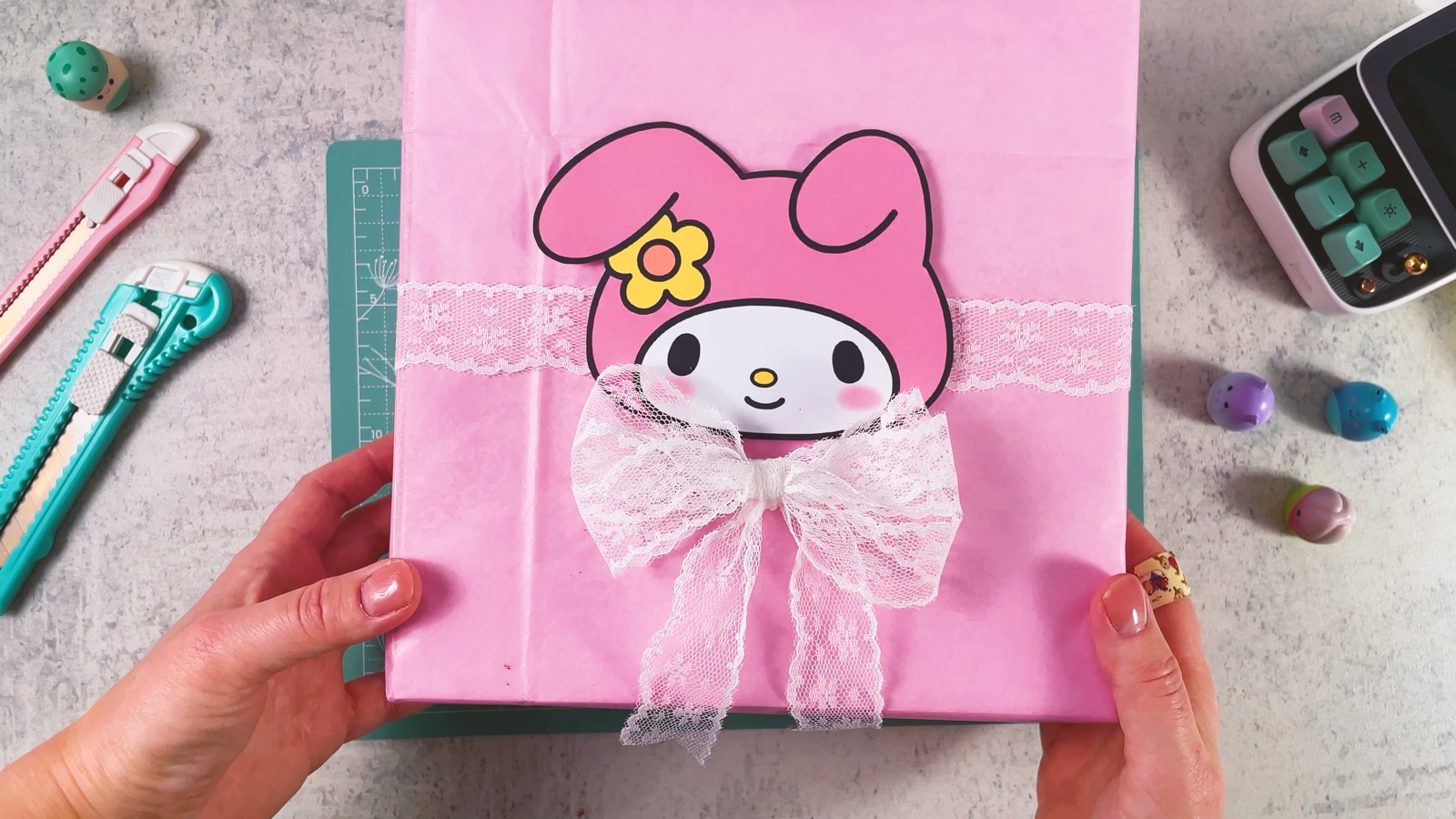 El regalo de My Melody terminado: caja rosa con encaje, la carita de My Melody y un moño de encaje blanco