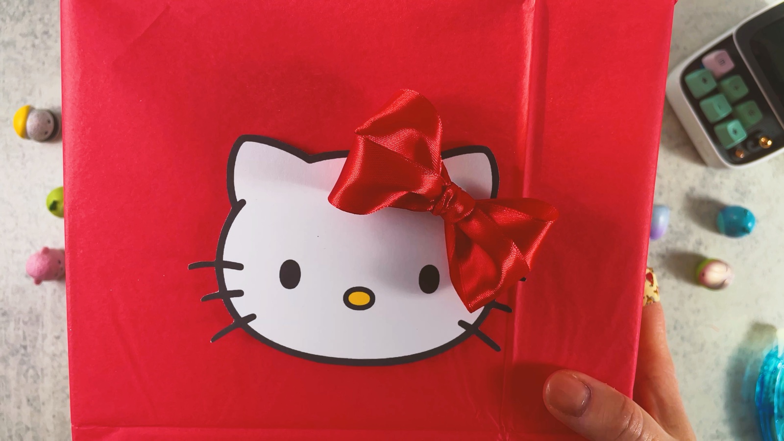 Se coloca el moño de satín rojo en la oreja de Hello Kitty