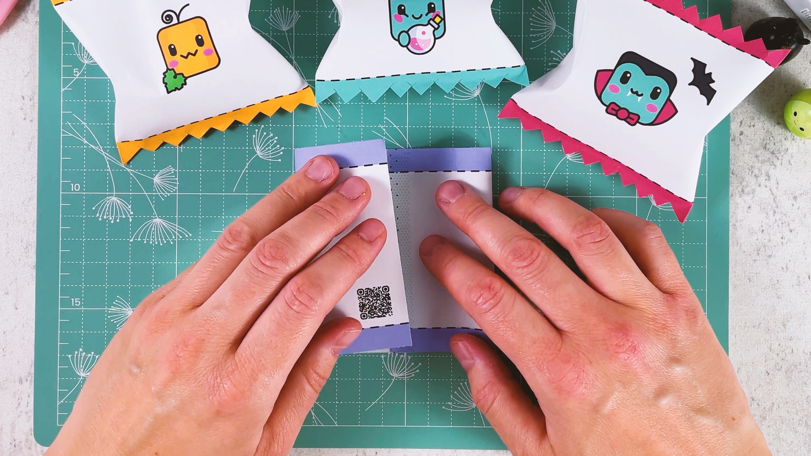 Pressing the two short ends of the strip together in the middle to make a flat tube