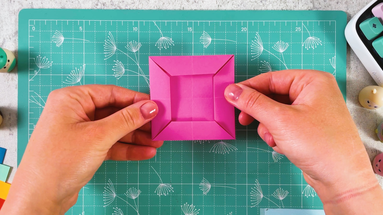The pink paper folded into a smaller square with a folded band on every side, like a picture frame