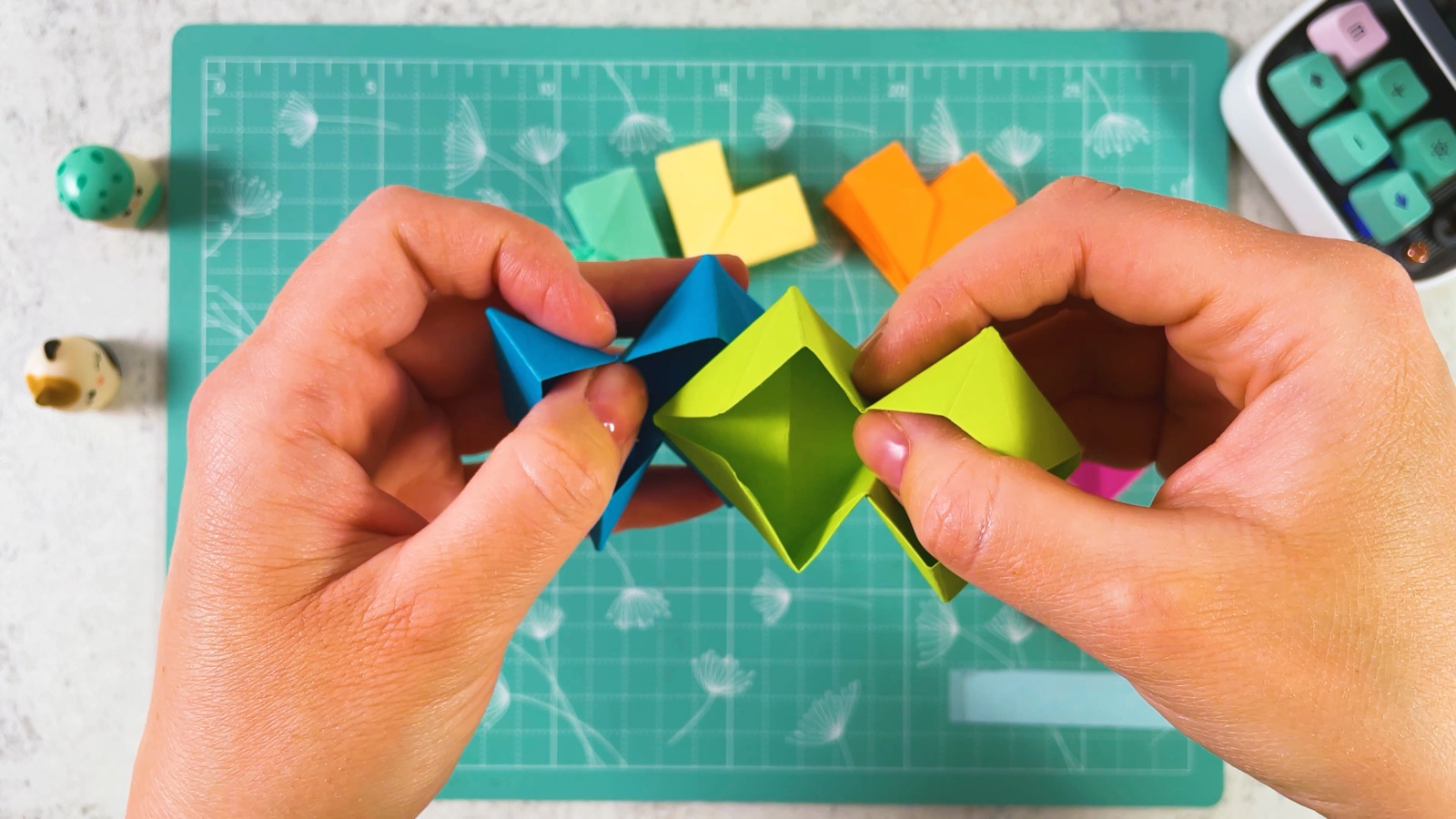 Pushing a blue piece and a green piece together so they lock into each other