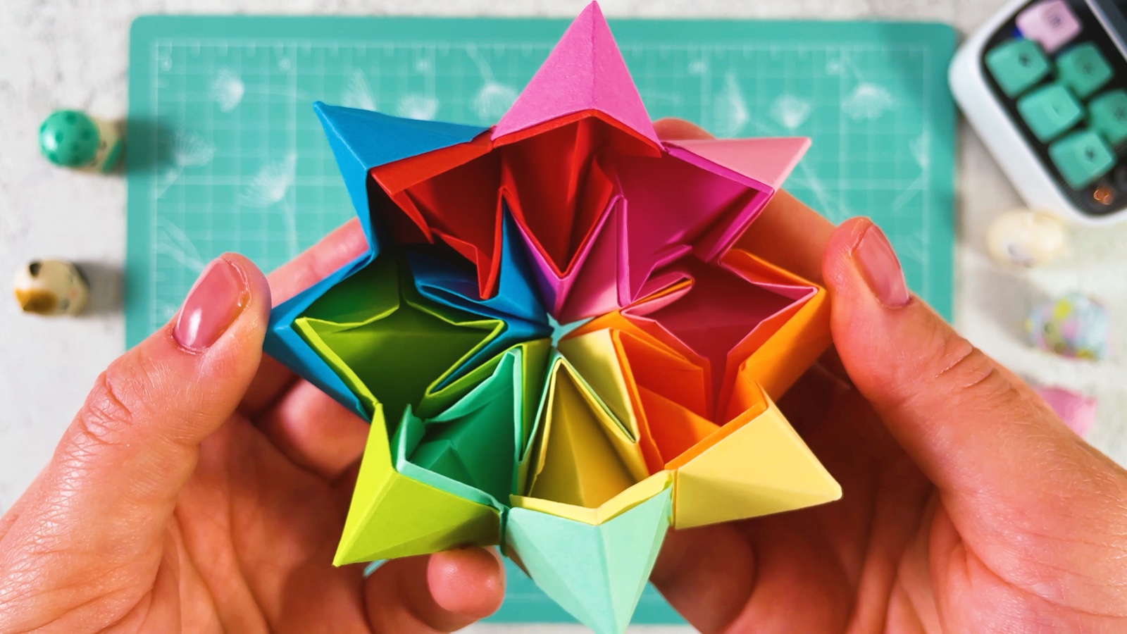 The rainbow paper toy opened into a deep crown shape, with pointed tips standing up around the edge