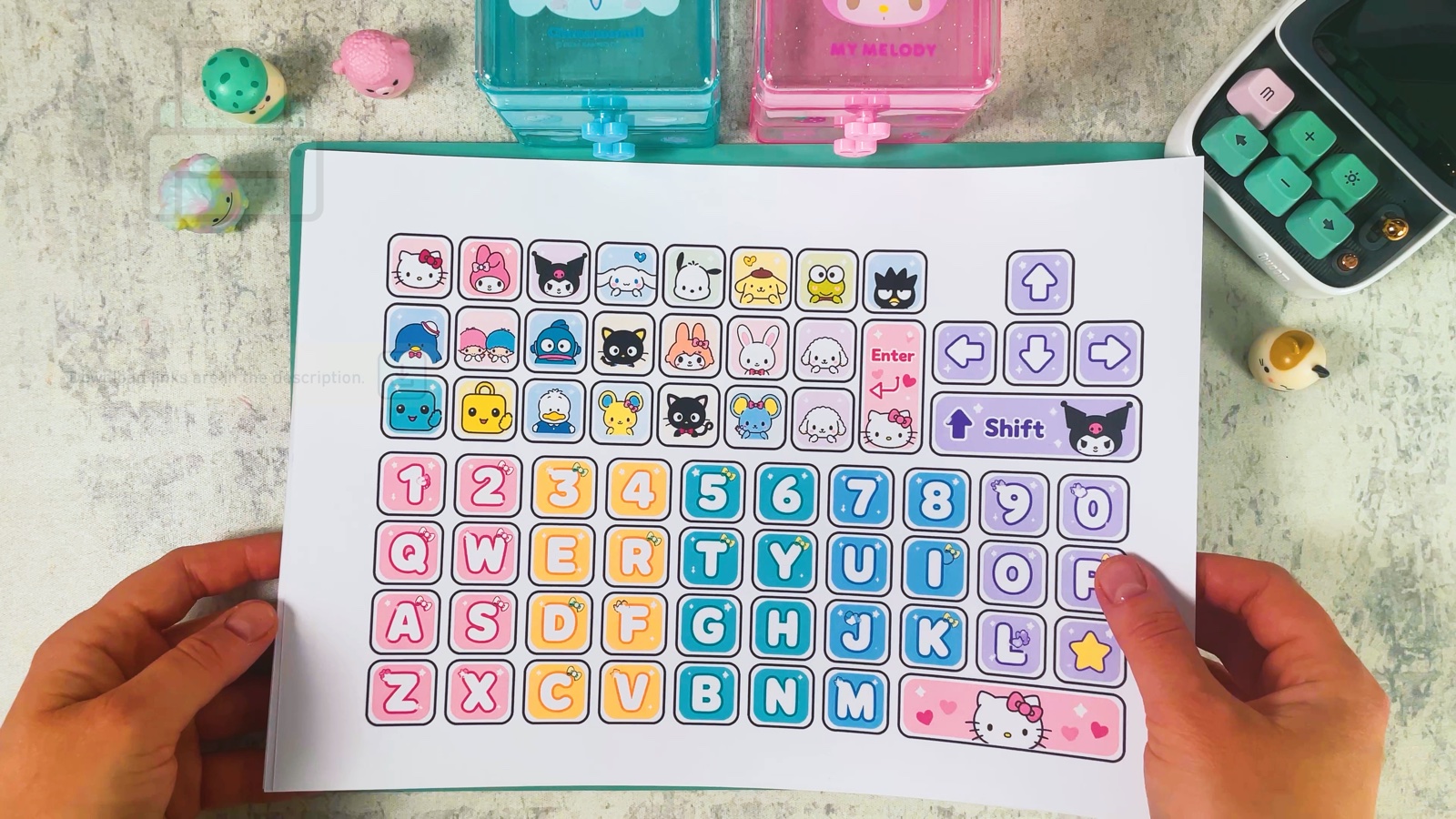 Das ausgedruckte Tastenblatt mit Pastell-Buchstaben, Zahlen und Hello-Kitty-Figuren über der Schneidematte