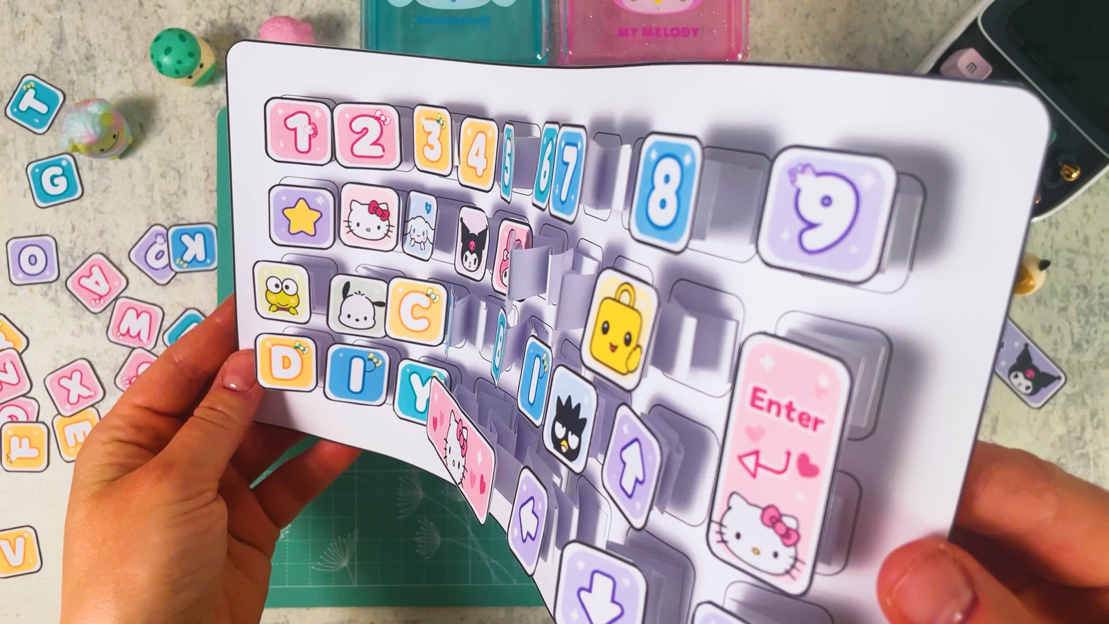 Die Tastatur wird hochgehalten und leicht gebogen, unter jeder Taste sind die Papierfedern zu sehen