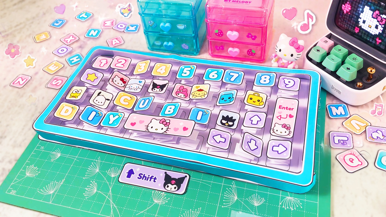 A finished bouncy paper keyboard with kawaii keys in its mint case, next to Hello Kitty treasures