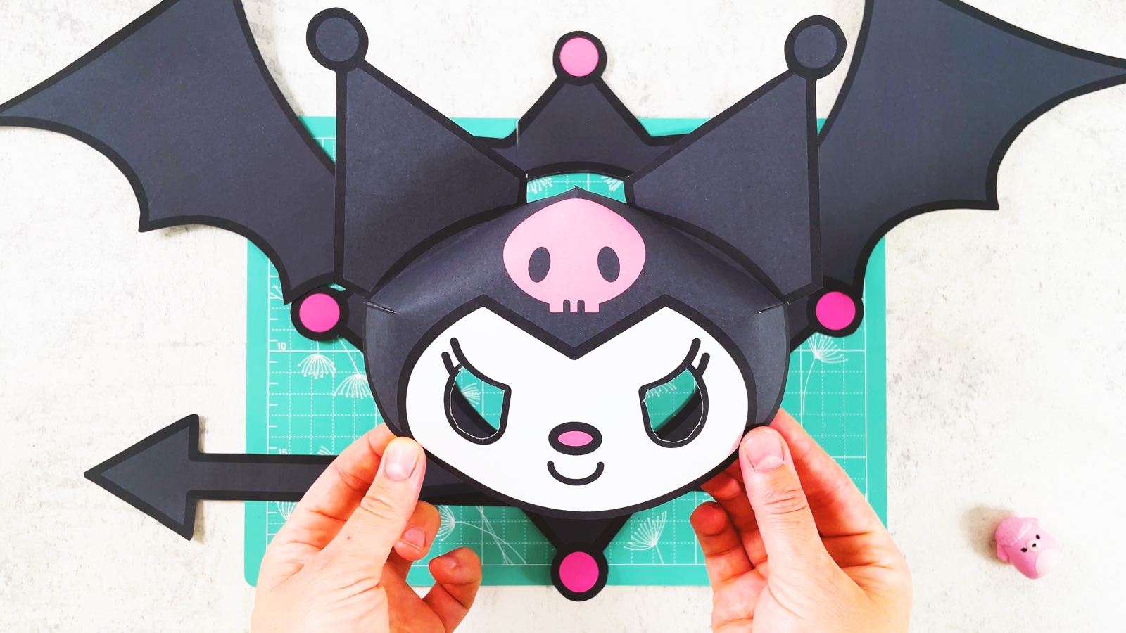 Finished paper Kuromi mask with pointy ears, a spiky collar, bat wings and an arrow tail