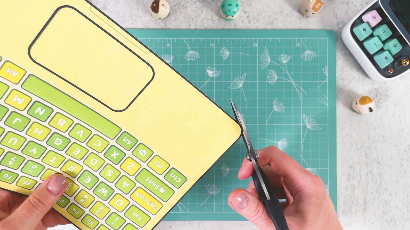 Die gelbe Tastatur wird mit der Schere an der runden Ecke ausgeschnitten
