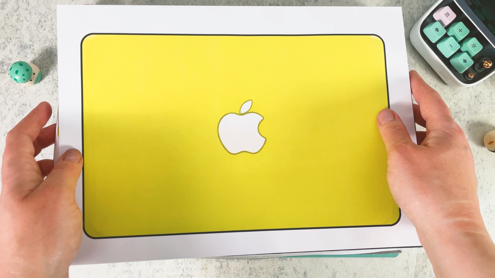 Der fertige Deckel der Schachtel, oben gelb, mit einem weißen Apple-Logo