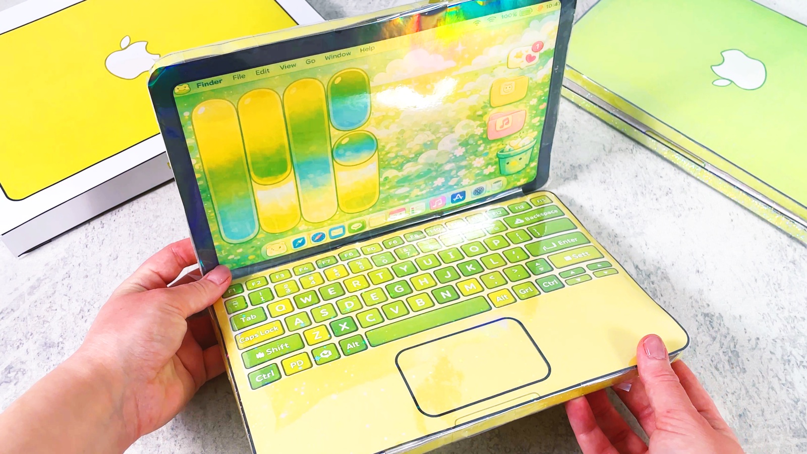 Finished squishy paper MacBook Neo, open, next to its paper box