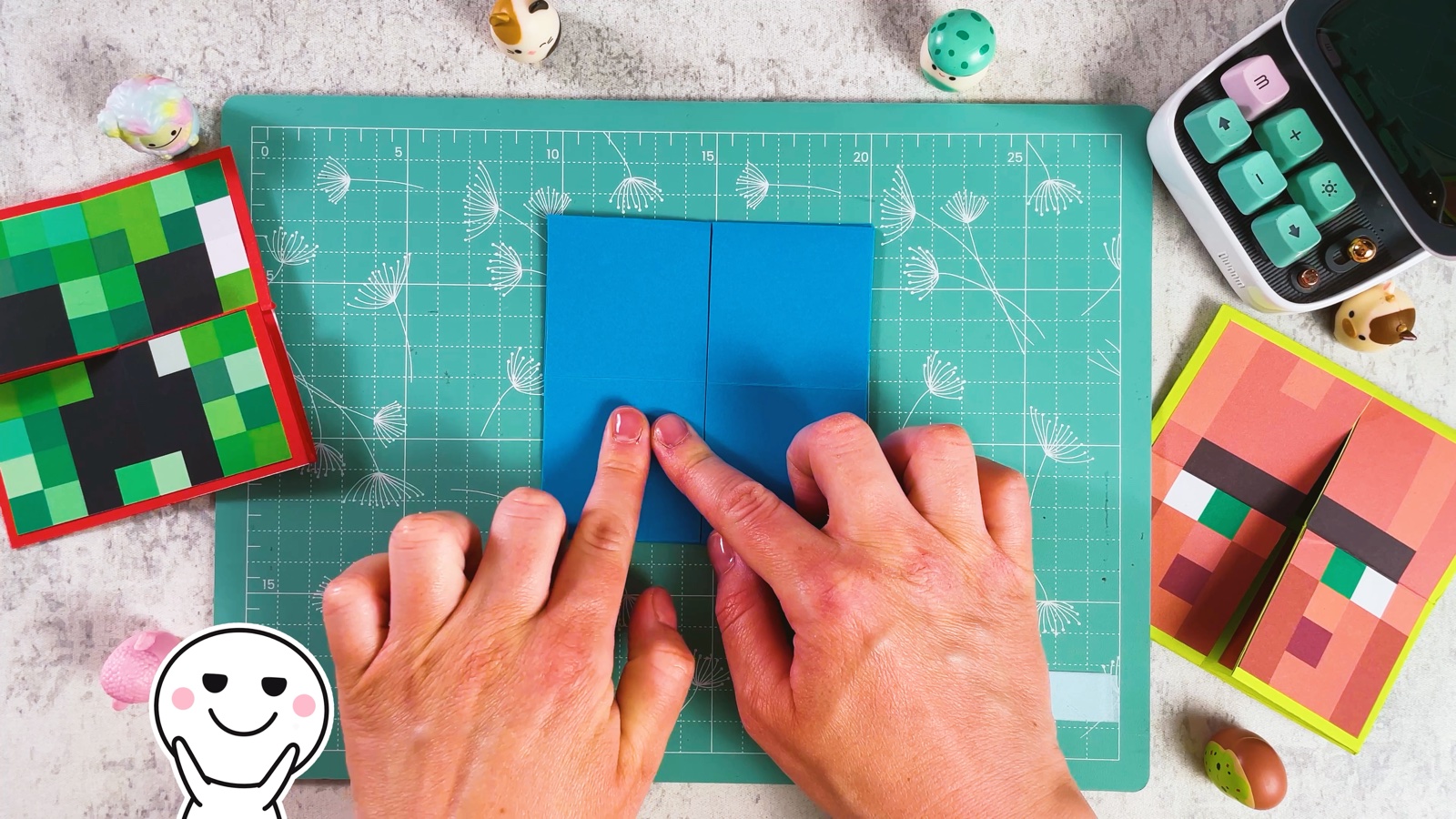 Pressing the blue paper flat into a small square with a slit down the centre