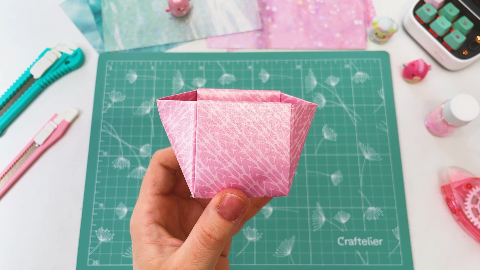 Die rosa Papierschachtel in Form einer Einkaufstasche, oben breiter
