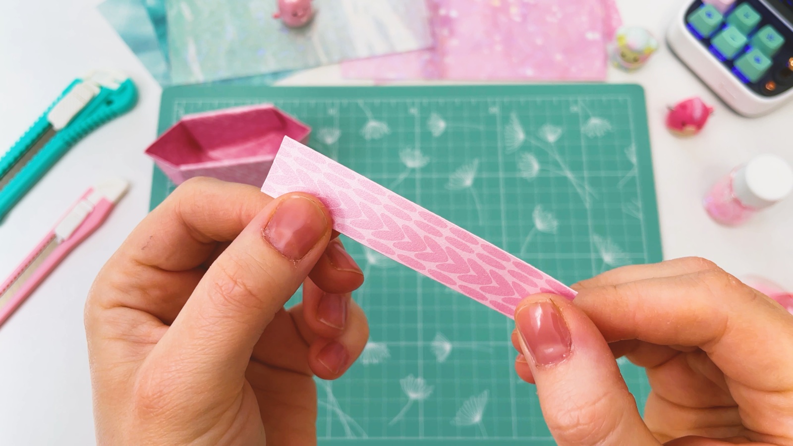 Der lange rosa Papierstreifen in der Hand, bevor er gefaltet wird