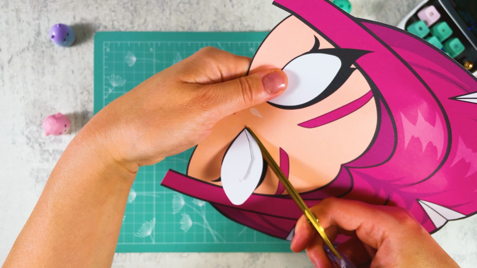 Cutting out the white eye hole of the paper mask with gold scissors