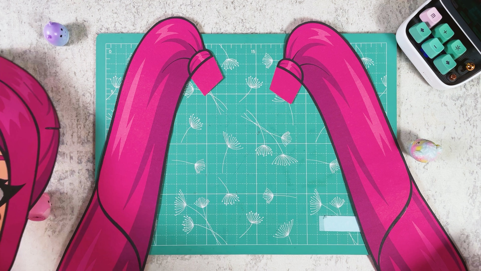 Two finished paper ponytails lying side by side, each with a small tab next to the hair tie