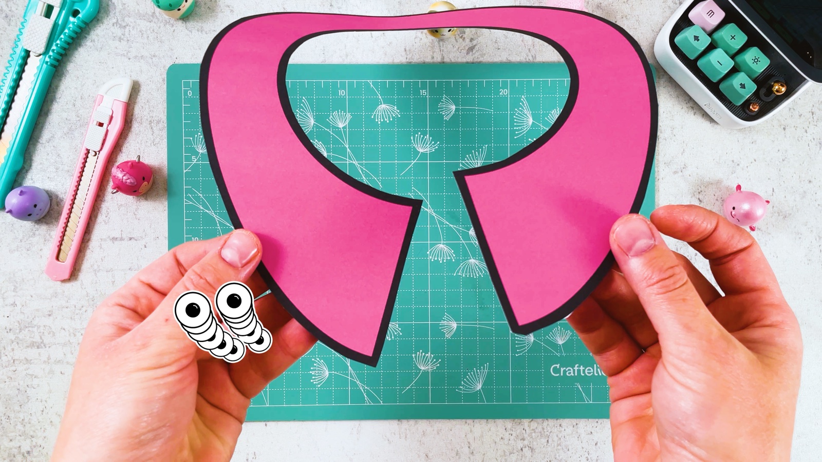 Der ausgeschnittene rosa Kragen wird vorne offen gehalten