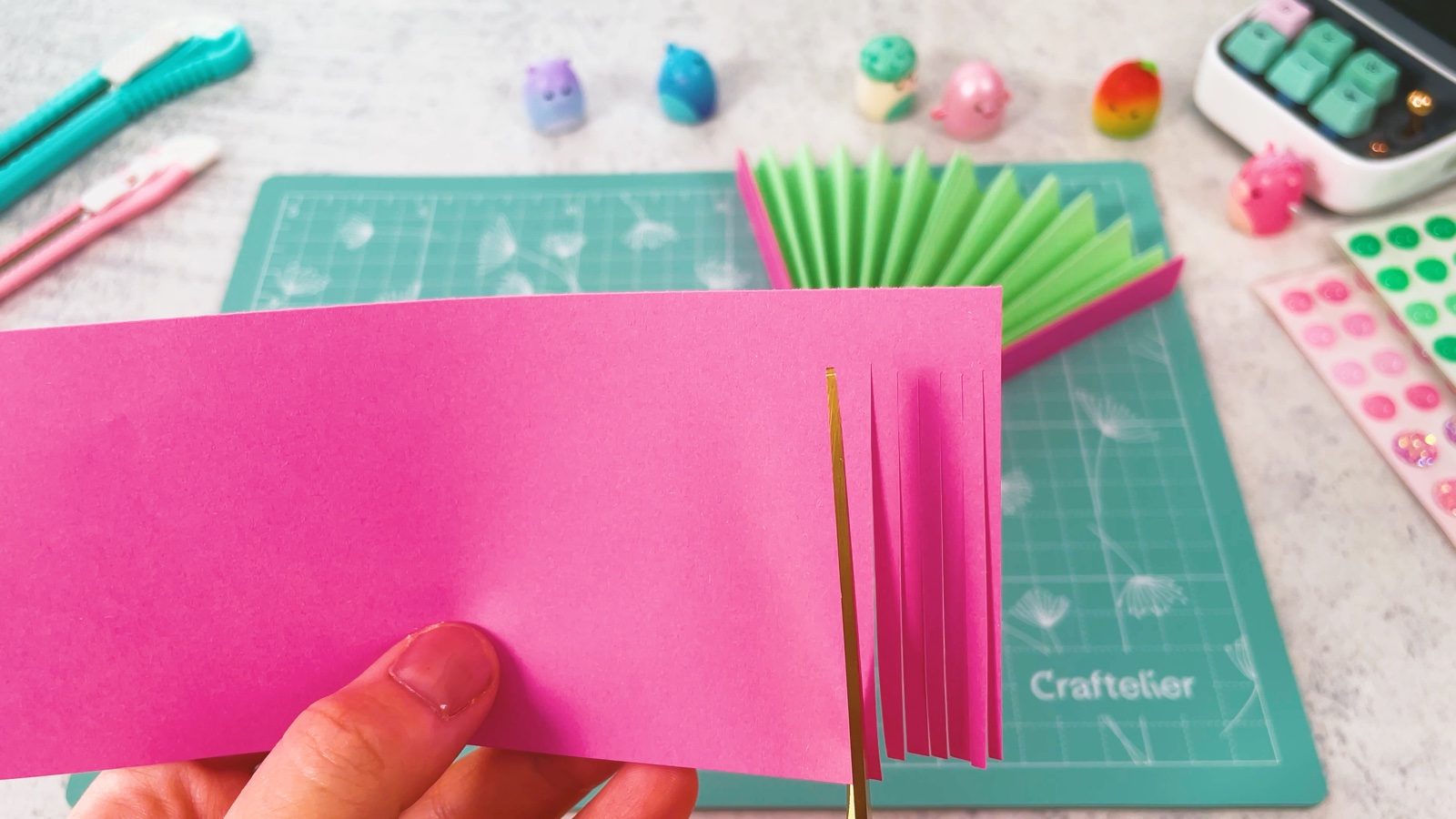 Des franges fines découpées aux ciseaux dans un rectangle de papier rose
