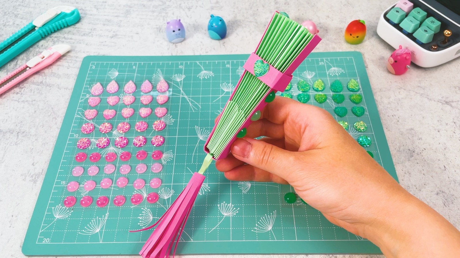 L’éventail terminé, fermé avec l’anneau rose et son strass en forme de cœur, le pompon rose qui pend en bas
