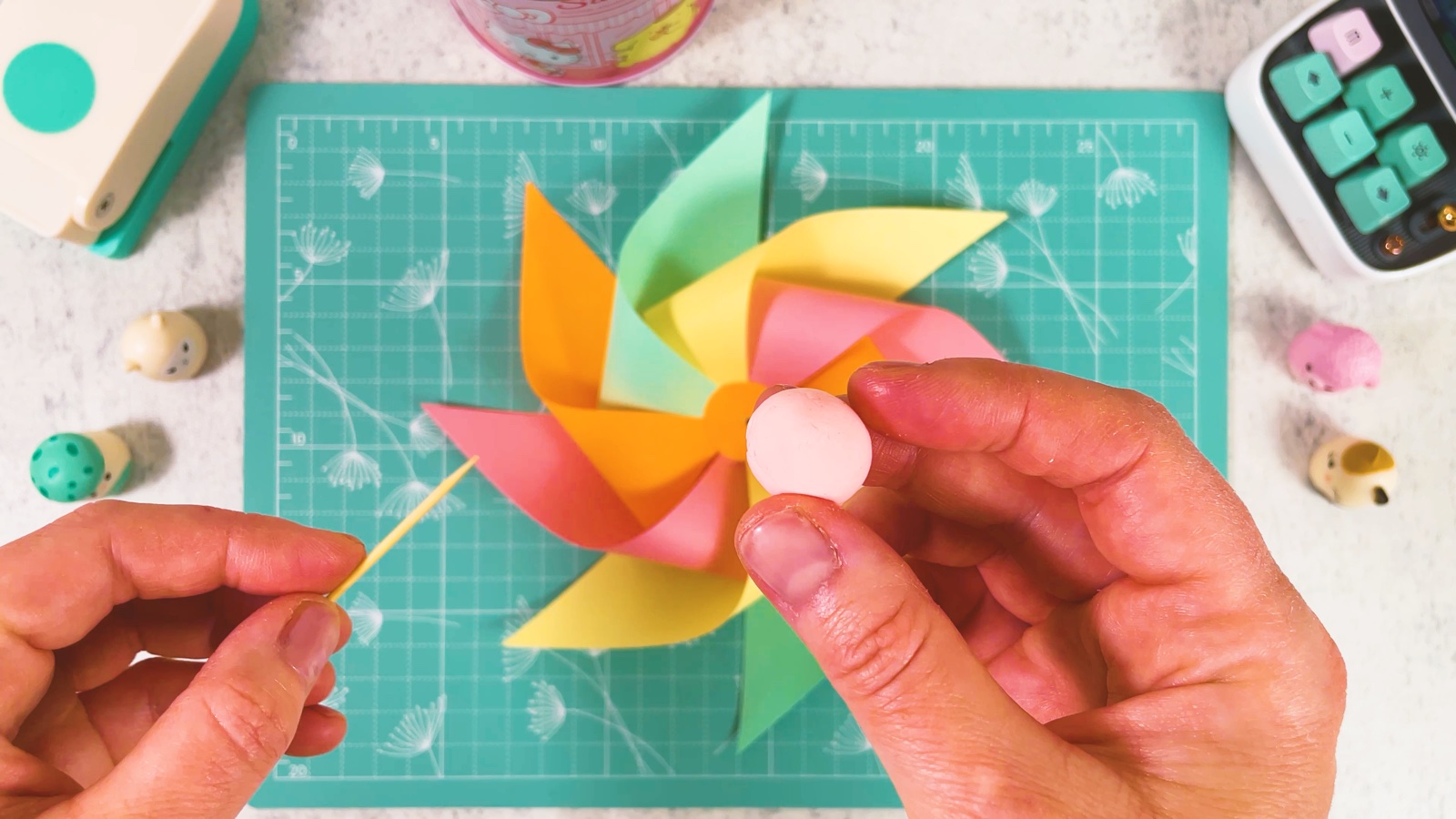 Eine kleine rosa Kugel aus Modelliermasse neben dem Windrad, der Zahnstocher schaut seitlich heraus
