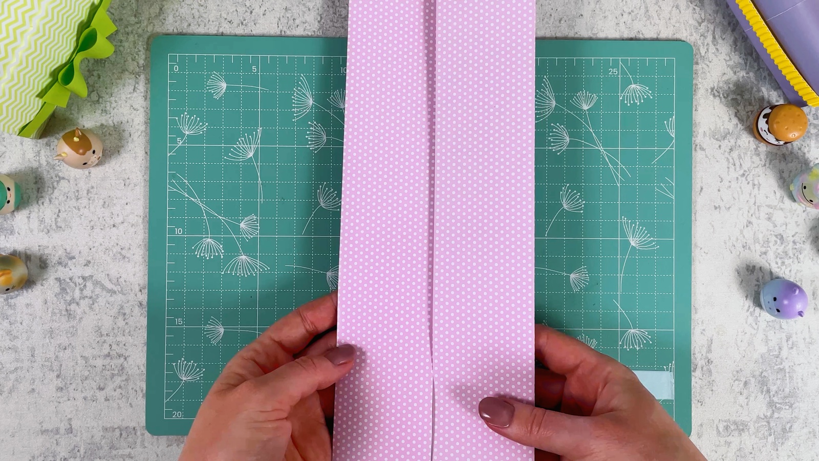 The pink strip folded in half the short way, standing upright on the cutting mat