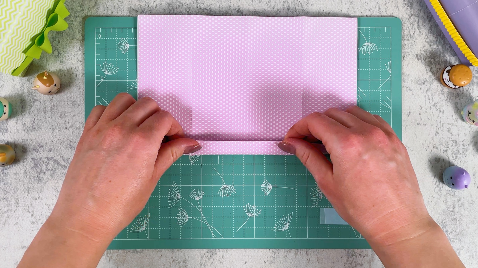 Folding a narrow band along the bottom edge of the folded pink paper