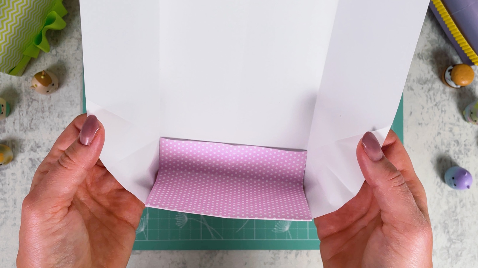 The bottom of the purse shaped into a small open box, with the long back still standing up