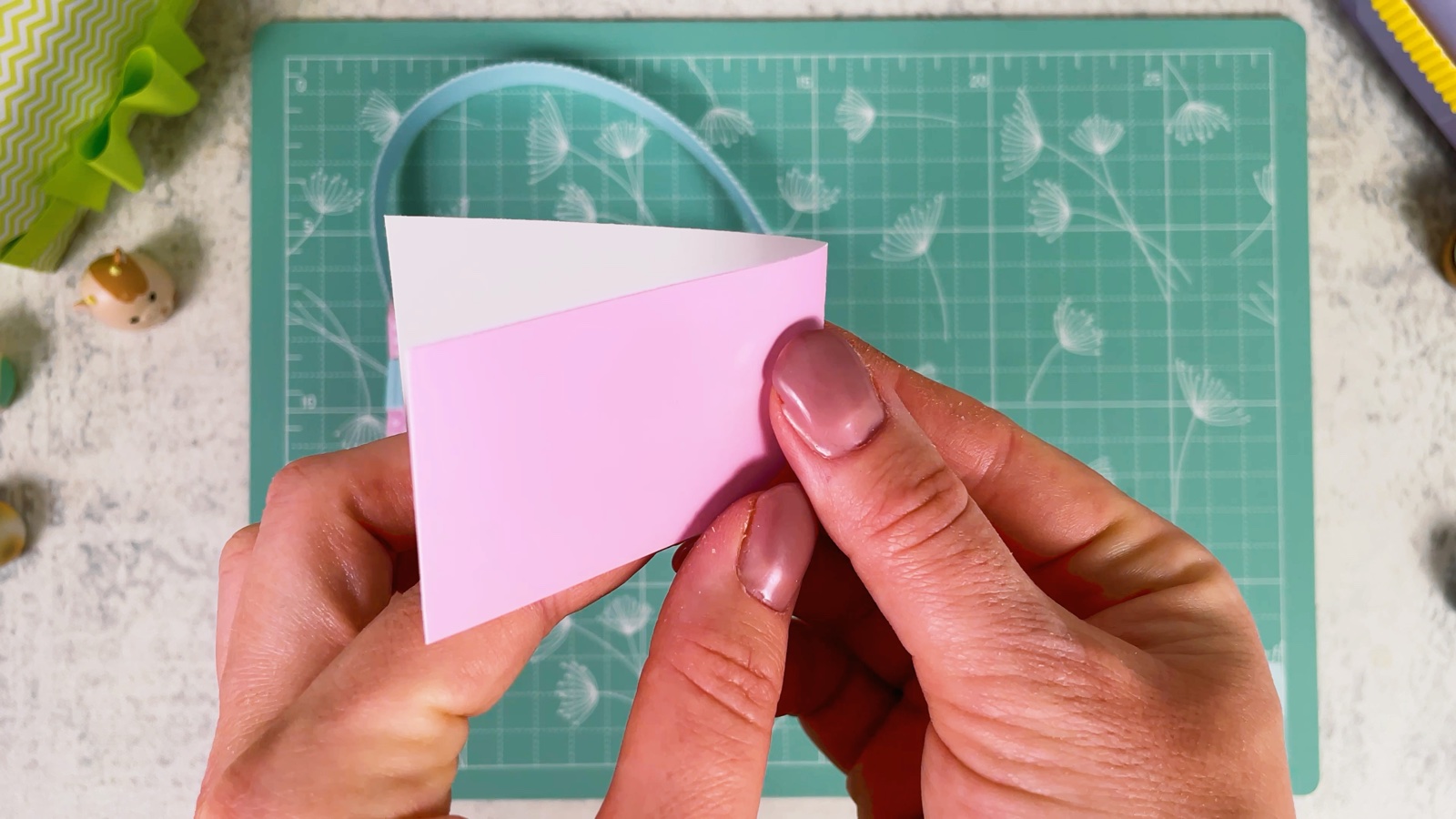 Folding a pink paper rectangle in half