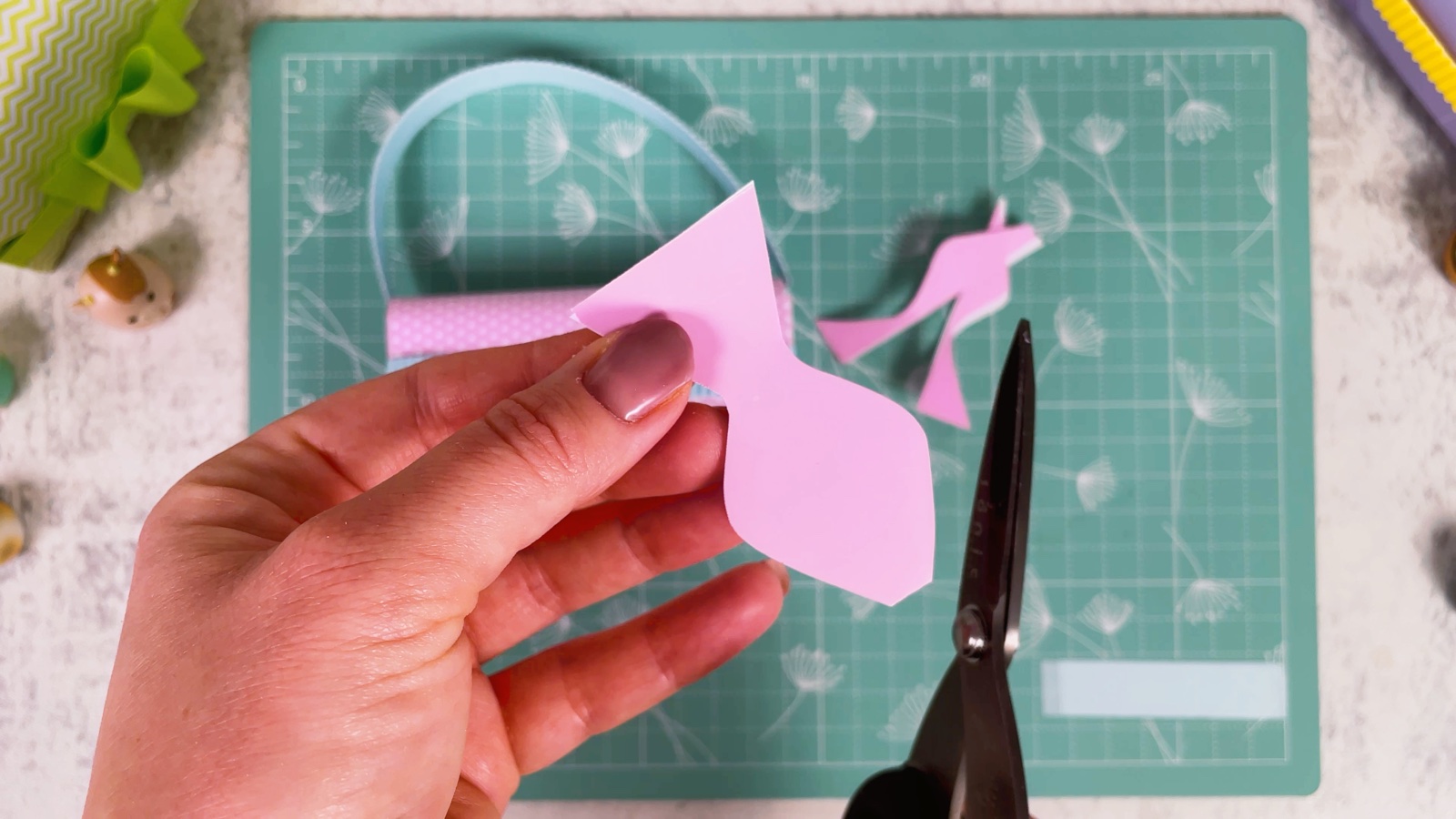 Cutting a wavy bow shape from the folded pink paper