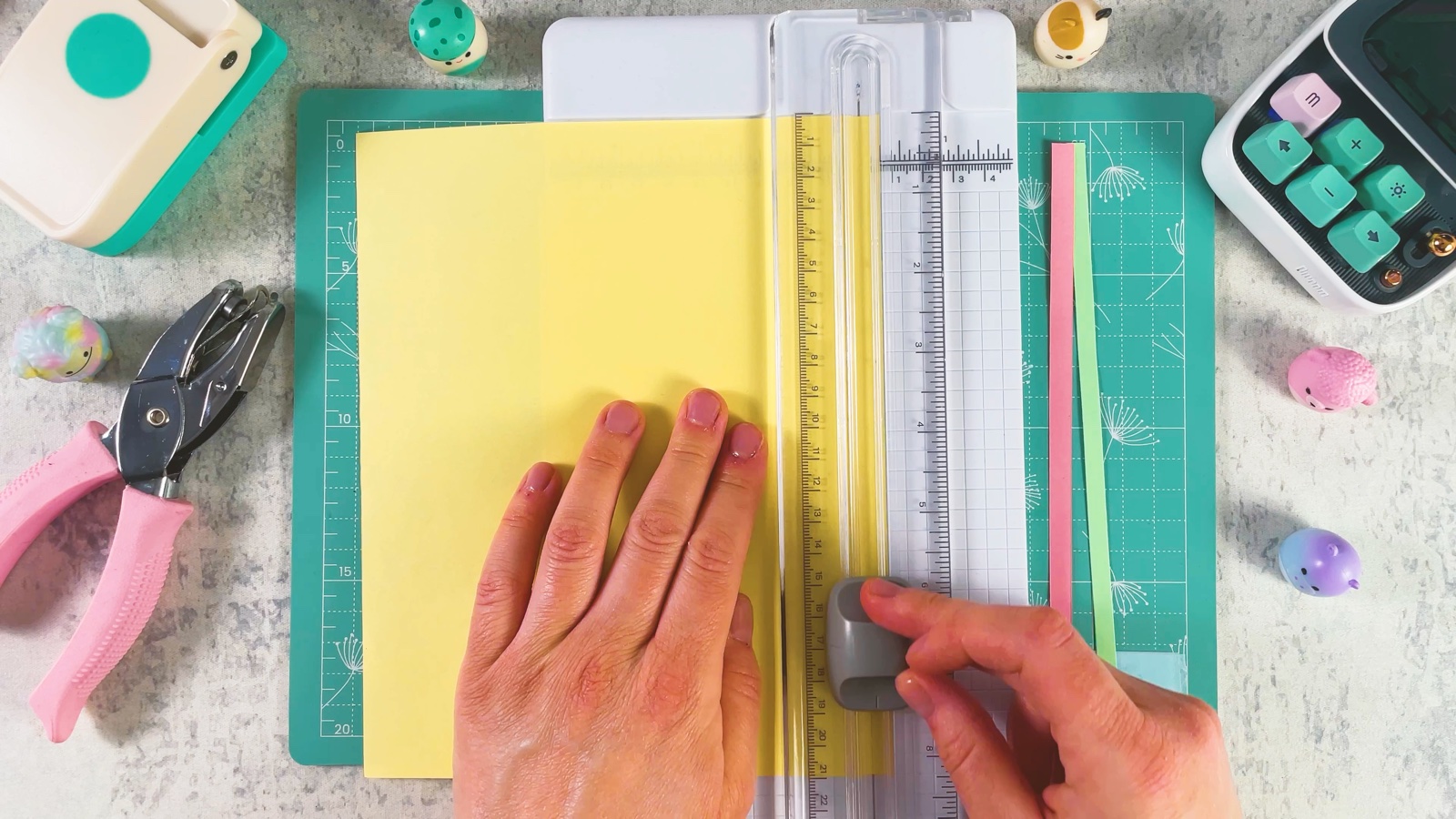 Se corta una tira delgada de papel amarillo con una guillotina, con tiras ya cortadas al lado