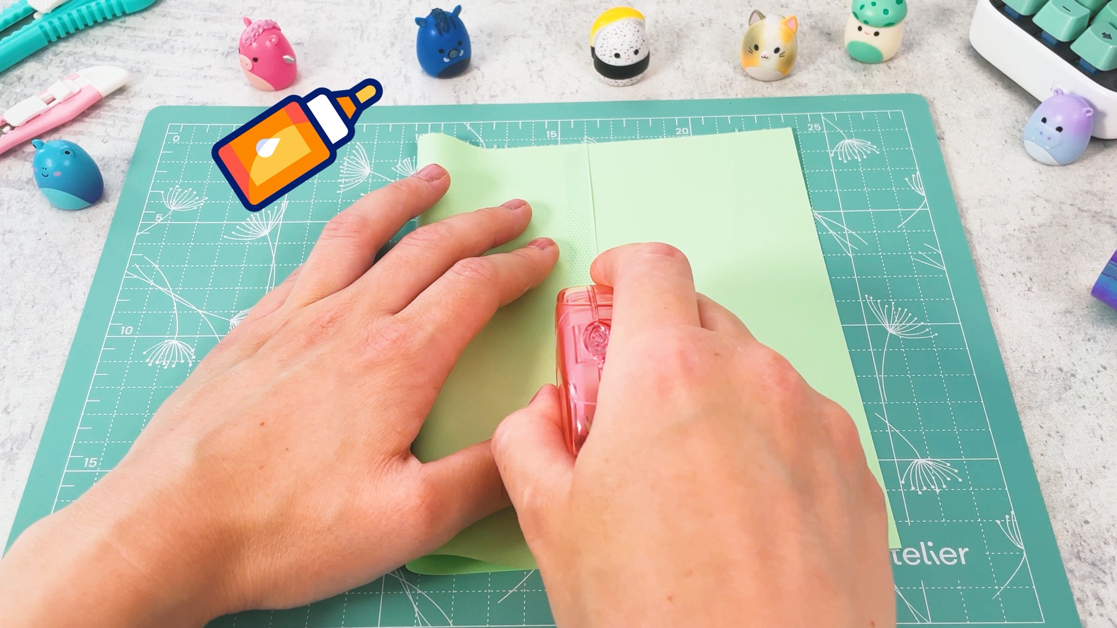 Putting glue along the edge of the folded side of a green paper square