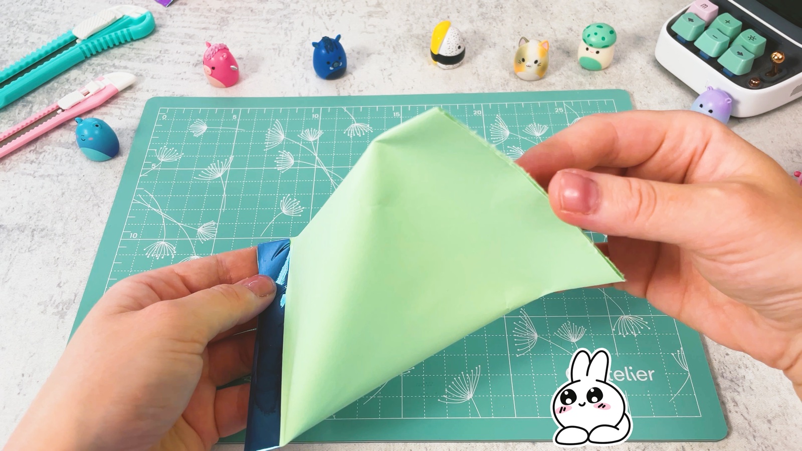 Pinching the open top of the bag crosswise so it turns into a pyramid shape