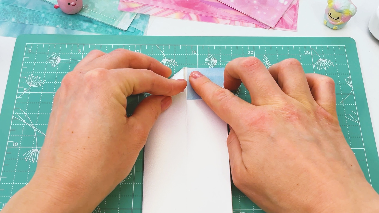 Folding a top corner of the strip down into a small triangle