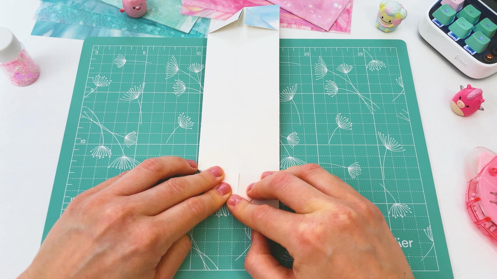 Folding the bottom corners of the strip into triangles