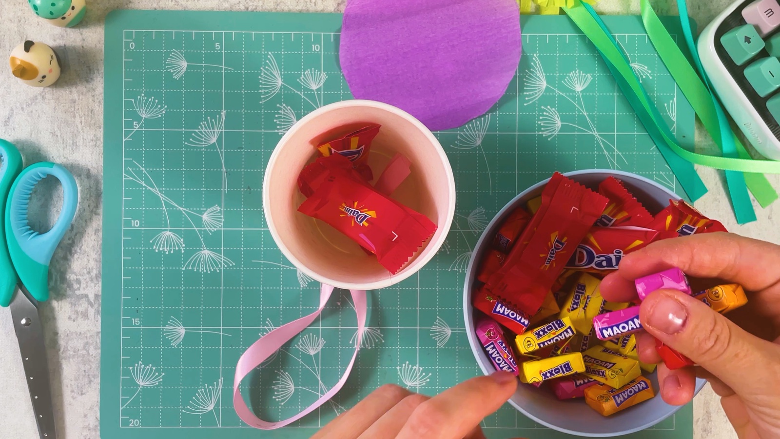 Putting wrapped sweets from a bowl into the paper cup