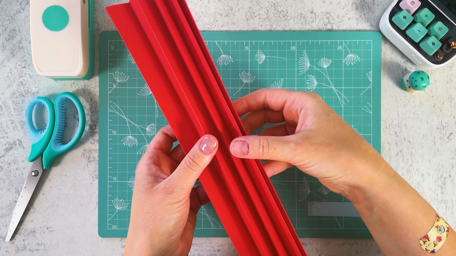 Sosteniendo la hoja roja doblada en un acordeón largo y angosto