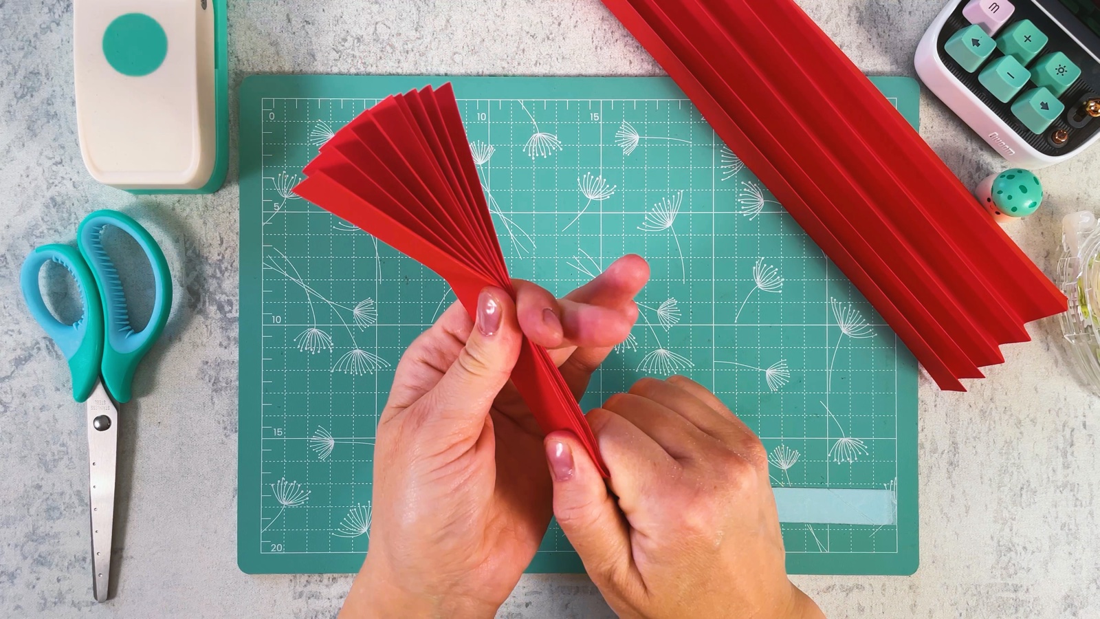 Abriendo el acordeón rojo pegado en un pequeño abanico