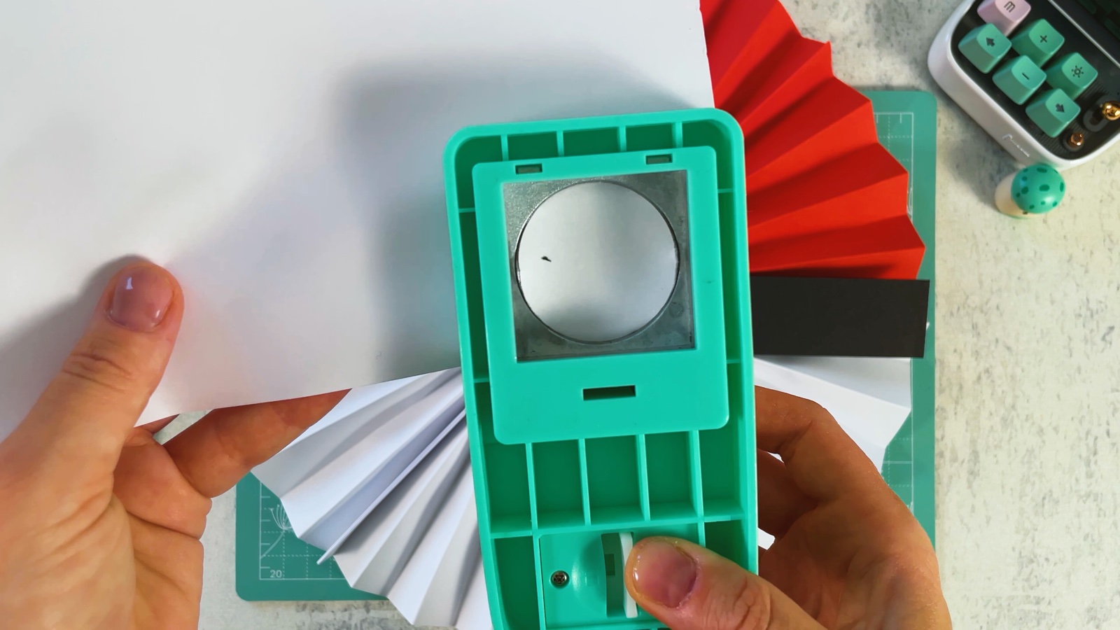 Sacando un círculo de papel blanco con una perforadora de círculos