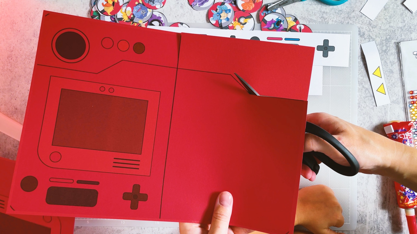 Recortando con tijeras el cuerpo rojo del Pokédex