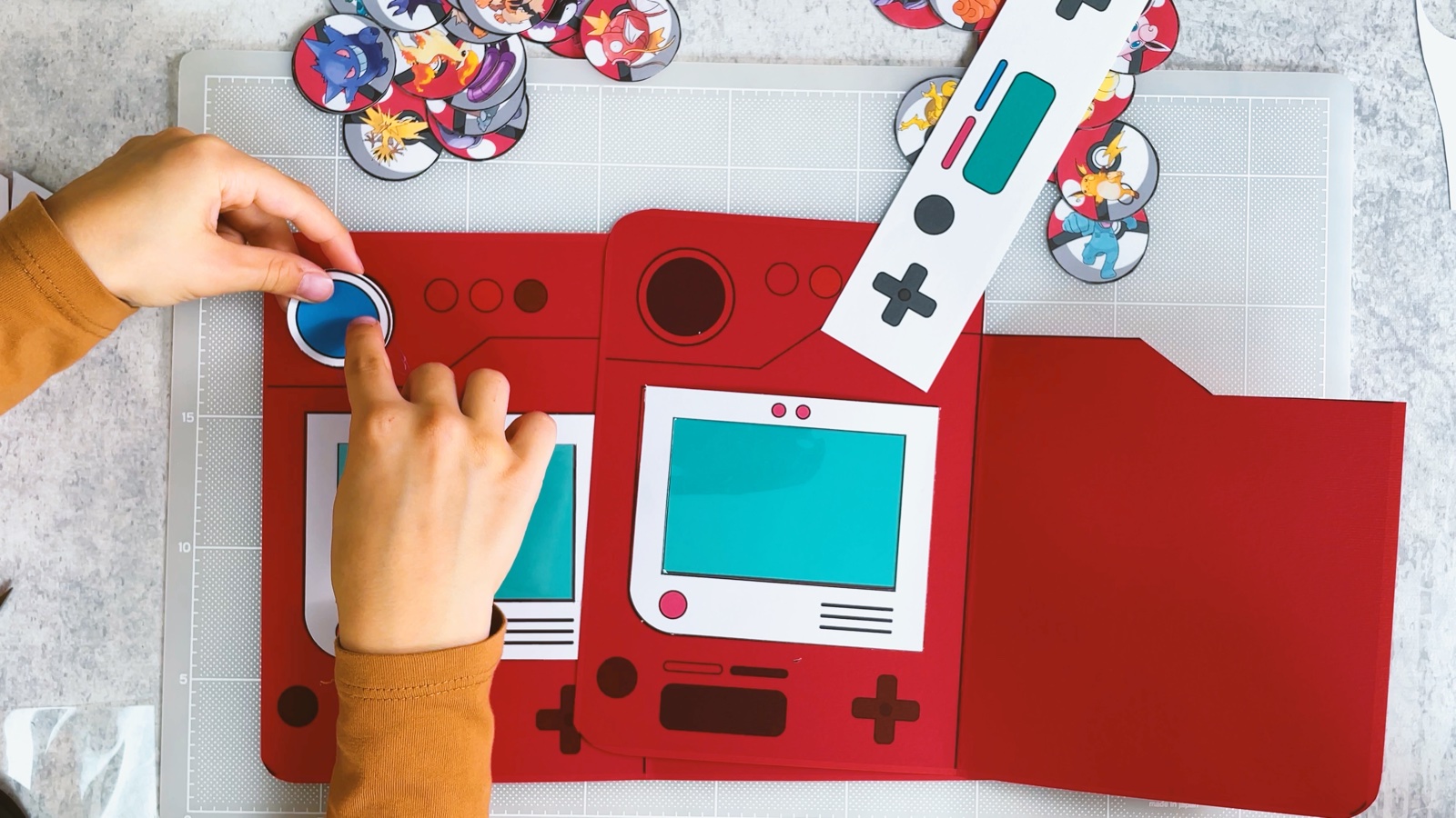 Un niño presiona el lente azul en la parte de arriba del Pokédex