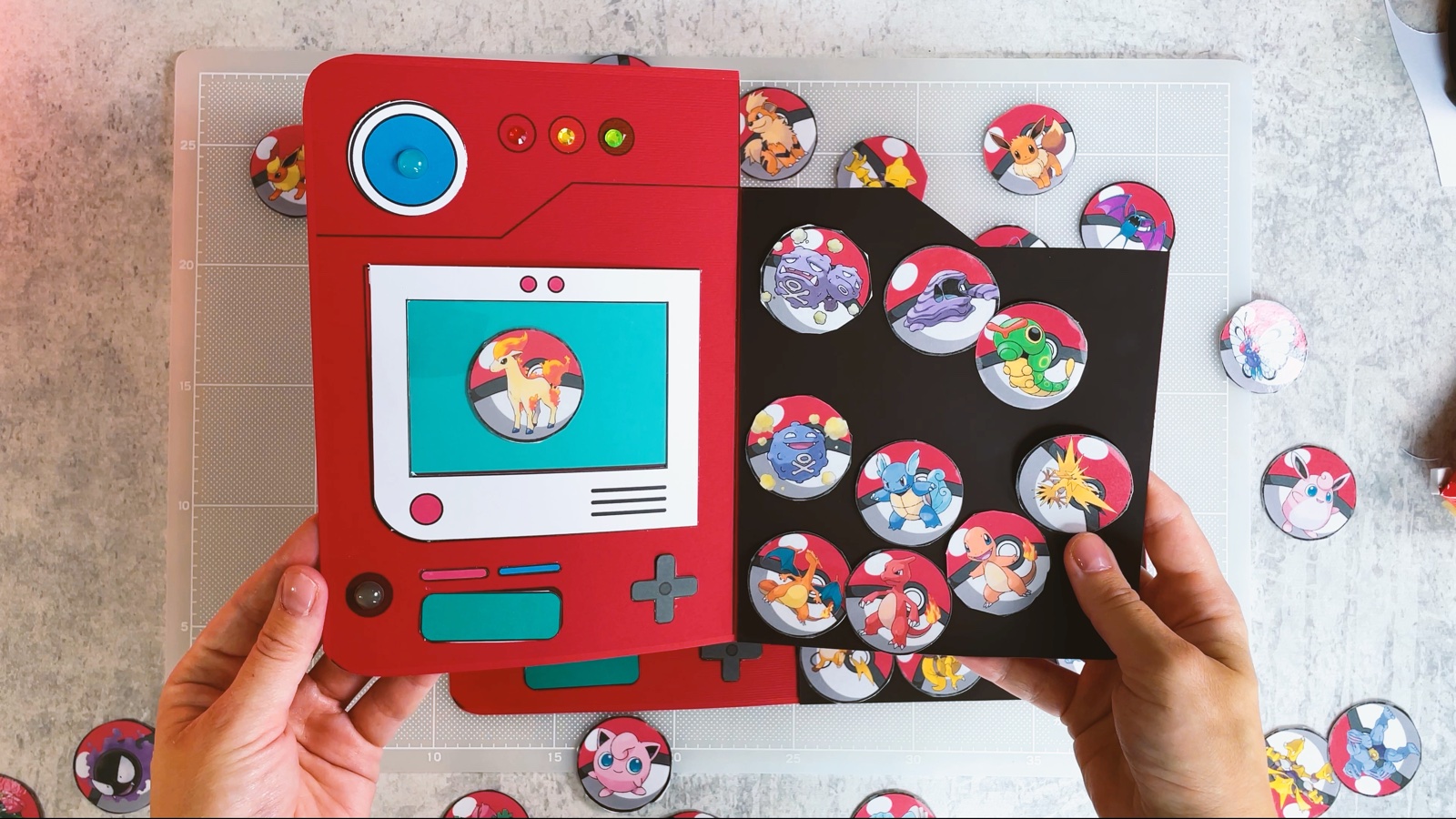 El Pokédex magnético terminado, abierto, con un Pokémon en la pantalla y la página magnética llena de fichas