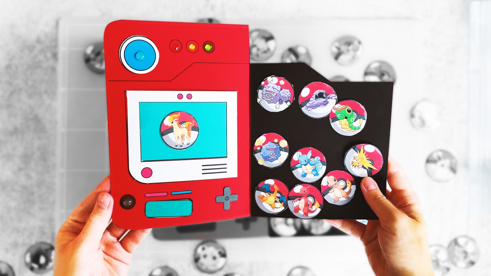 An open paper Pokédex with Pokémon tokens on a magnetic page