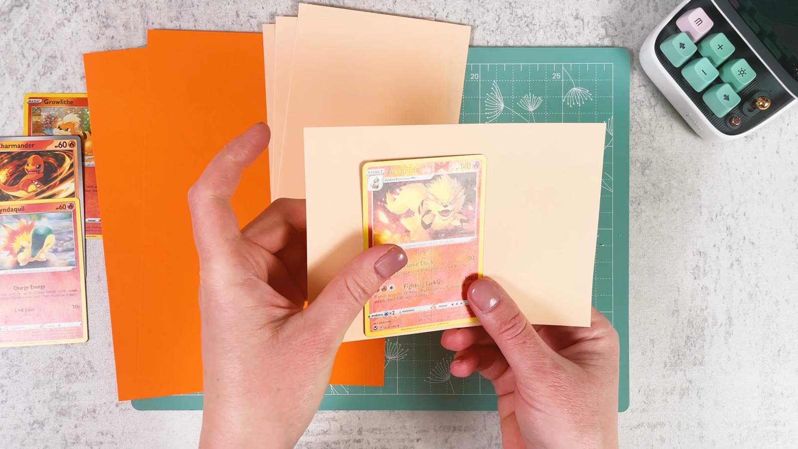 Placing a Pokémon card in the middle of a piece of peach paper