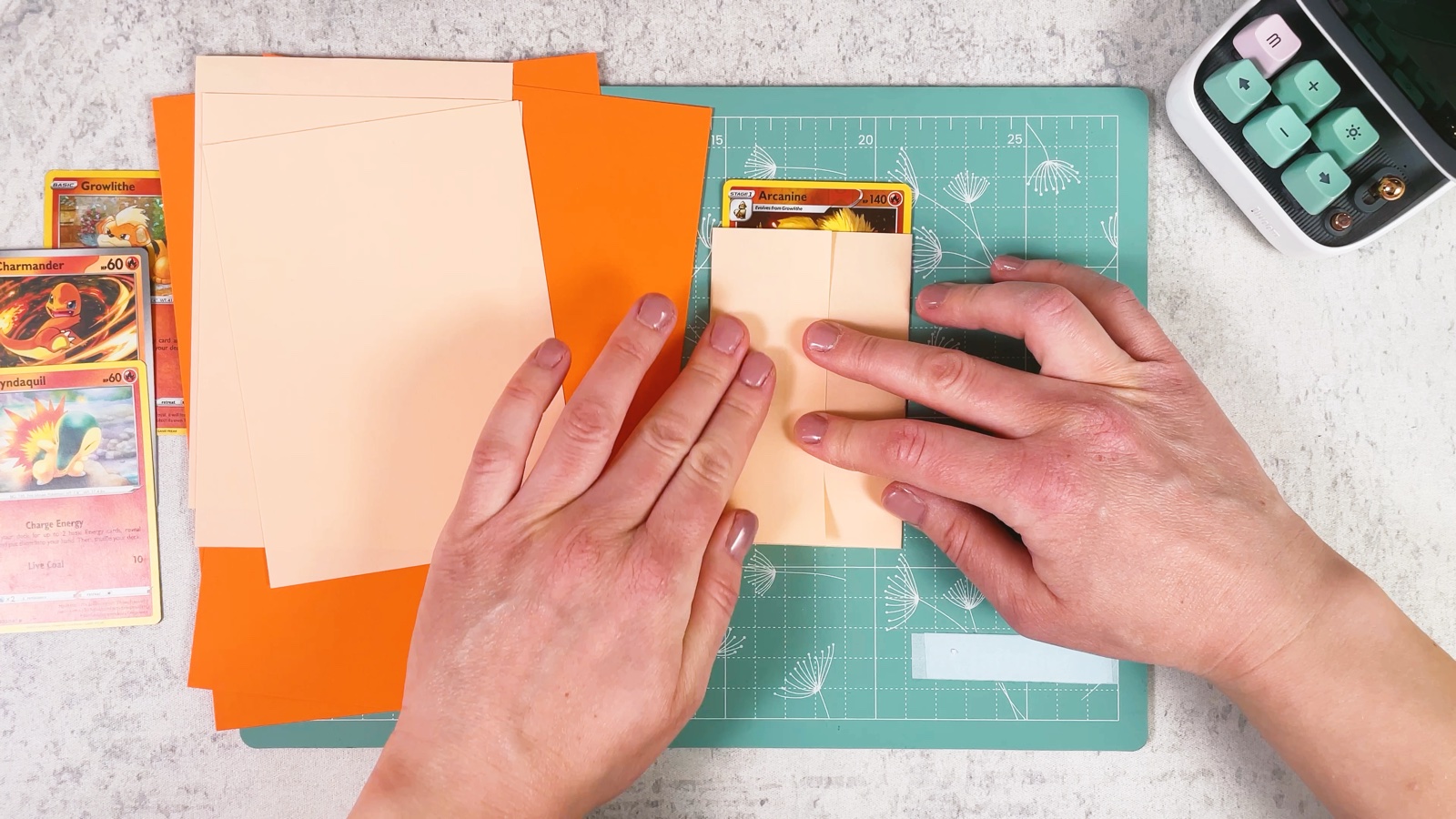 Pressing the left side of the paper over the card, so both sides cover it