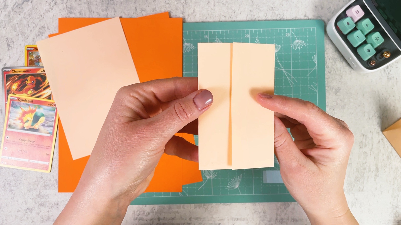 Holding the folded paper strip with two side flaps meeting in the middle