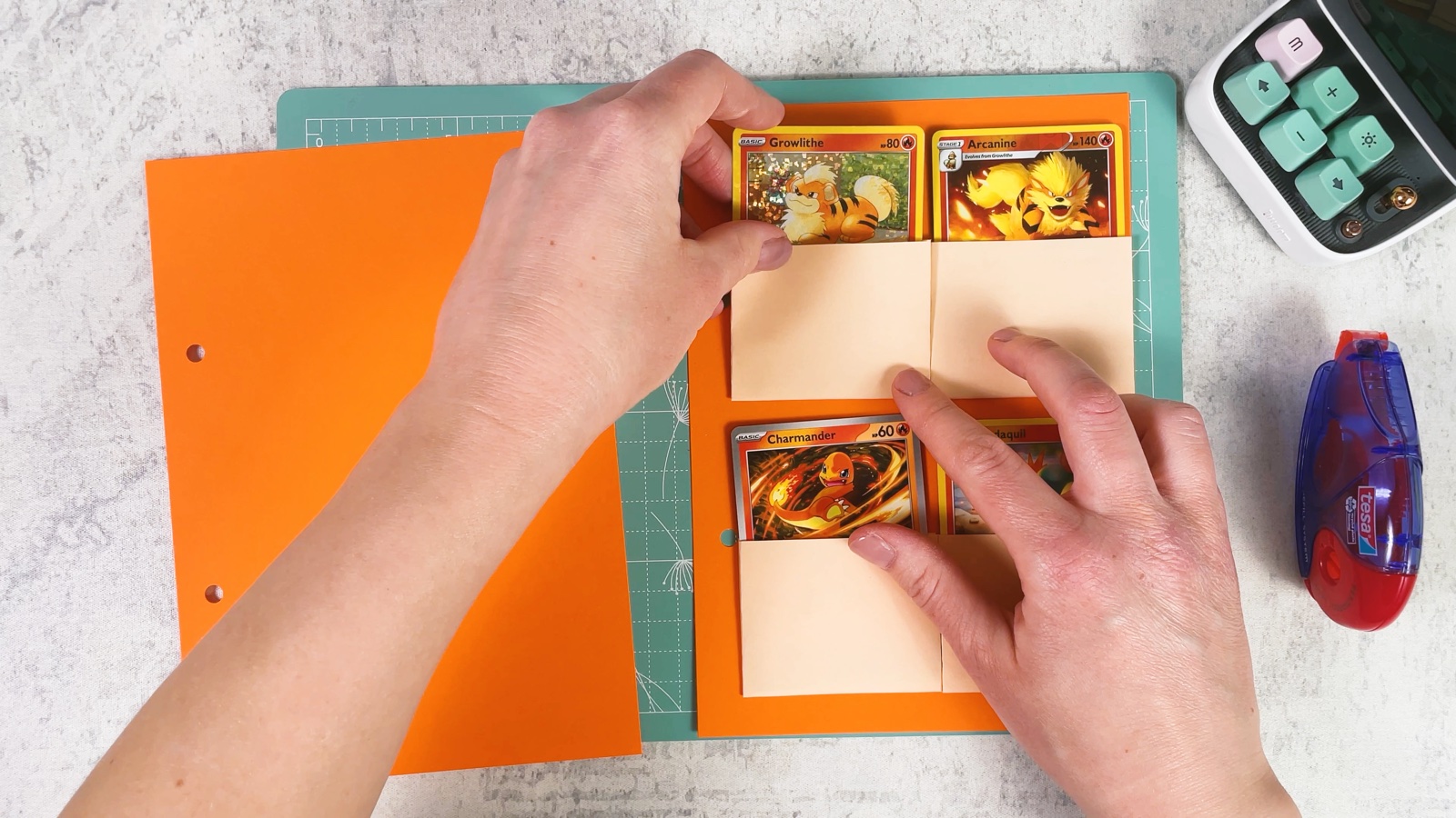 Pressing four pockets with Fire Pokémon cards onto an orange page